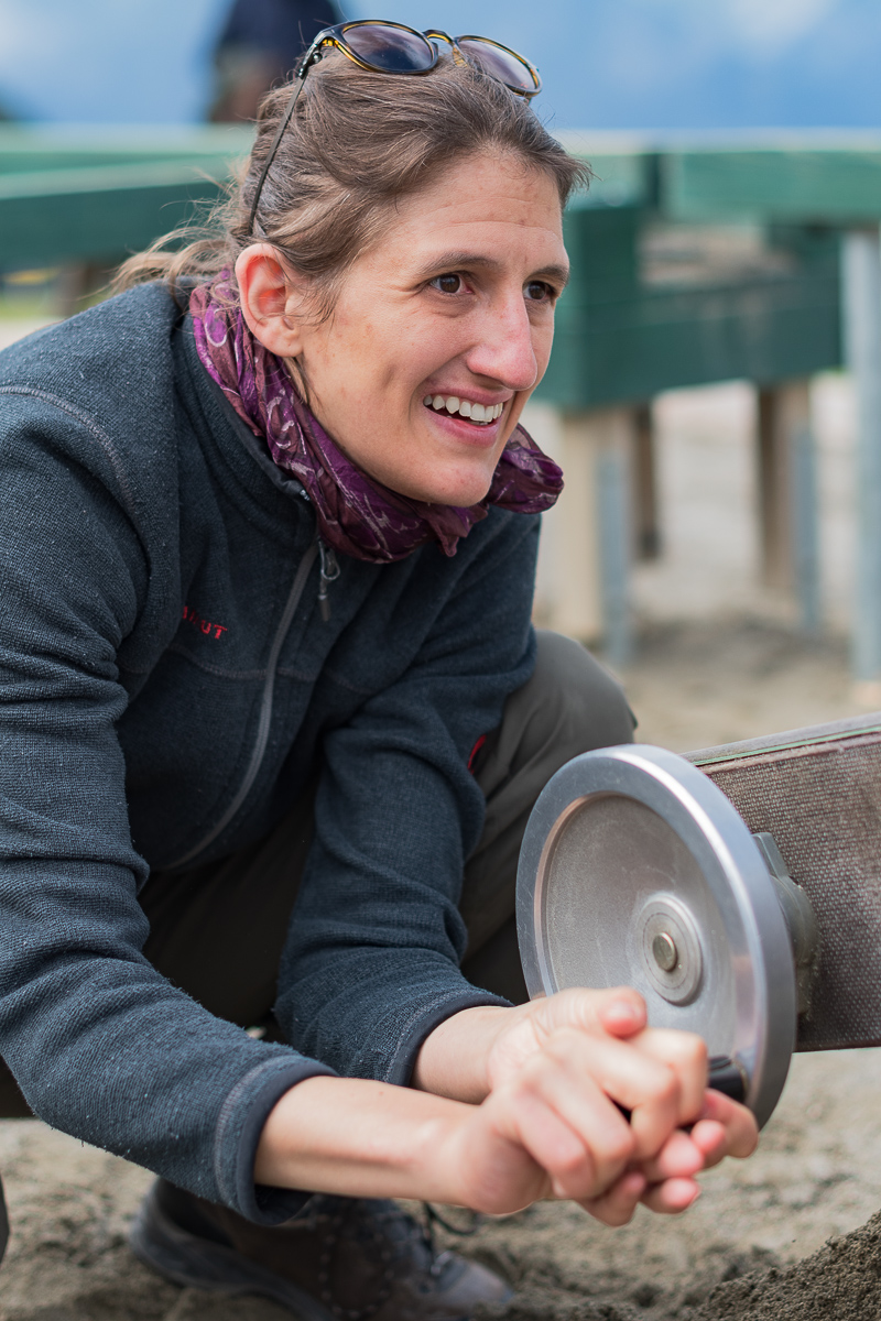 Frau kurbelt an einem Fließband auf einem Spielplatz in Seefeld, Tirol. Das Handwerk geht Hand in Hand mit der Natur und mit dem Menschen. Zusammen etwas bewegen.